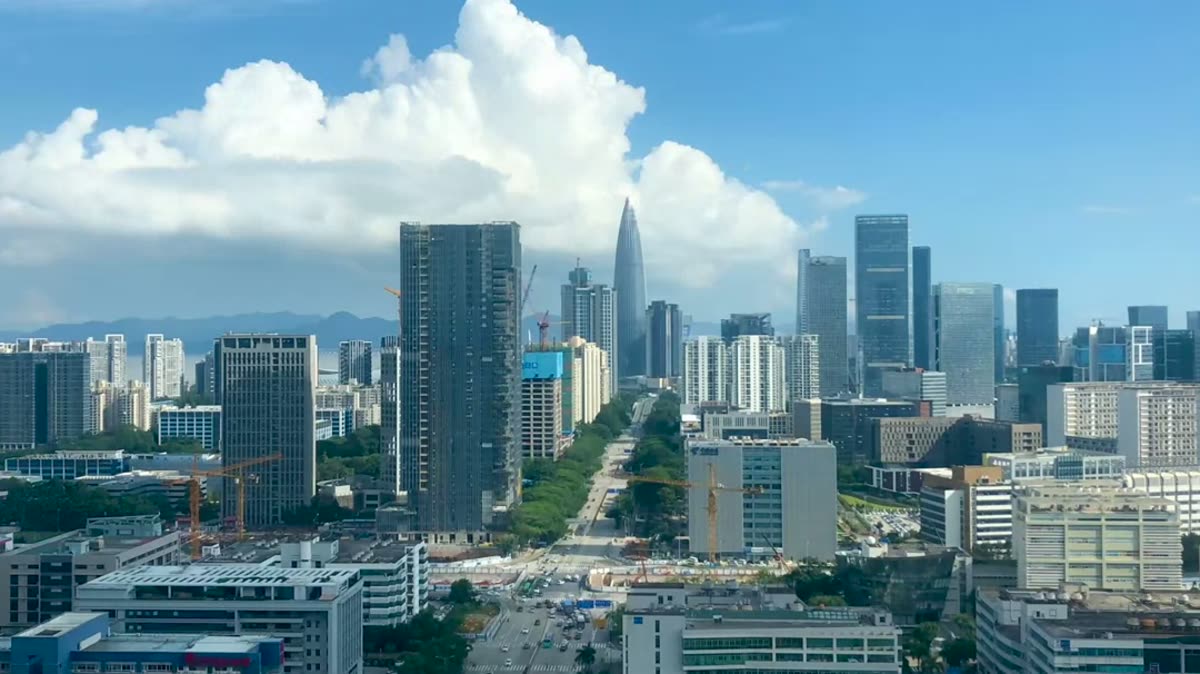 A slow view across the Nanshan technology district in Shenzhen: towers, trees and cumulus clouds